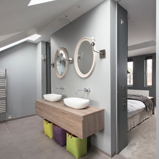 Imagen de cuarto de baño principal, actual, con lavabo sobreencimera, armarios con paneles lisos y paredes grises