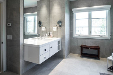 サンディエゴにあるコンテンポラリースタイルのおしゃれな浴室 (フラットパネル扉のキャビネット、白いキャビネット、アンダーカウンター洗面器、グレーのタイル) の写真