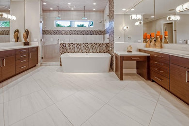 Inspiration för mellanstora moderna en-suite badrum, med släta luckor, skåp i mellenmörkt trä, ett fristående badkar och bänkskiva i kvarts