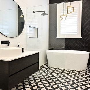 Photo of a mid-sized contemporary master bathroom in Brisbane with flat-panel cabinets, dark wood cabinets, a freestanding tub, an open shower, black tile, white tile, white walls, a vessel sink, multi-coloured floor, an open shower and beige benchtops.