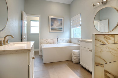 オースティンにある広いトラディショナルスタイルのおしゃれなマスターバスルーム (アンダーカウンター洗面器、シェーカースタイル扉のキャビネット、白いキャビネット、コーナー型浴槽、白いタイル、グレーの壁、セラミックタイルの床) の写真