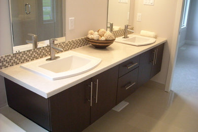 Modelo de cuarto de baño principal moderno con armarios con paneles lisos, puertas de armario marrones y encimera de laminado