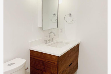 На фото: маленькая ванная комната в современном стиле с плоскими фасадами, темными деревянными фасадами, ванной в нише, душем в нише, раздельным унитазом, белой плиткой, керамической плиткой, белыми стенами, полом из терраццо, накладной раковиной, столешницей из искусственного кварца, серым полом, душем с распашными дверями и белой столешницей для на участке и в саду