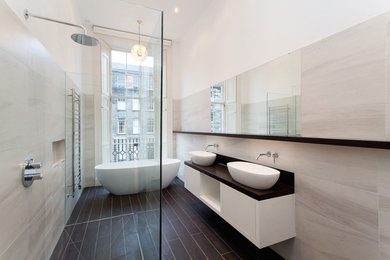 Пример оригинального дизайна: большая ванная комната в современном стиле с плоскими фасадами, белыми фасадами, столешницей из искусственного камня, отдельно стоящей ванной, открытым душем, белой плиткой, керамогранитной плиткой, белыми стенами, полом из керамической плитки, настольной раковиной и открытым душем