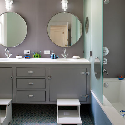 Inspiration for a mid-sized contemporary kids' mosaic tile floor, blue floor and double-sink tub/shower combo remodel in San Francisco with gray cabinets, flat-panel cabinets, gray walls, an undermount tub, an undermount sink, soapstone countertops, a hinged shower door, white countertops and a floating vanity