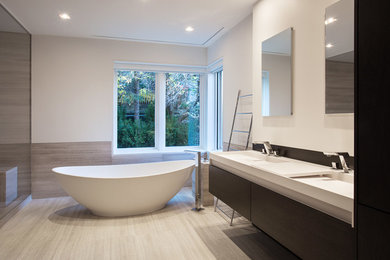 Bathroom - large contemporary master beige tile laminate floor and beige floor bathroom idea in Montreal with white walls, flat-panel cabinets, dark wood cabinets, an integrated sink and a hinged shower door