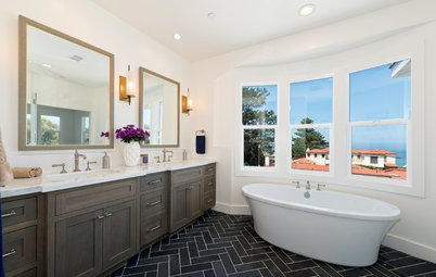 Dark-Floored Bathroom Offers Ocean Views From Tub and Shower