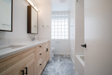 Photo of a small contemporary bathroom in Other with recessed-panel cabinets, light wood cabinets, white tiles, metro tiles, white walls, quartz worktops, grey floors, white worktops, a wall niche, double sinks and a built in vanity unit.