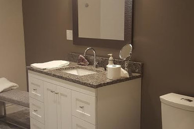 Ejemplo de cuarto de baño tradicional de tamaño medio con paredes marrones, suelo de baldosas de cerámica, lavabo bajoencimera, encimera de granito, puertas de armario blancas, armarios estilo shaker y sanitario de una pieza