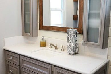 Inredning av ett modernt mellanstort vit vitt badrum med dusch, med luckor med upphöjd panel, grå skåp, en dusch i en alkov, en toalettstol med separat cisternkåpa, marmorkakel, grå väggar, mellanmörkt trägolv, ett undermonterad handfat, bänkskiva i kvarts, grått golv och dusch med duschdraperi
