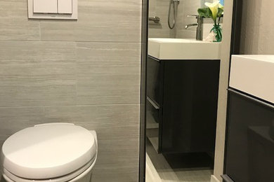Inspiration for a medium sized contemporary shower room bathroom in Other with flat-panel cabinets, black cabinets, an alcove shower, a wall mounted toilet, brown tiles, porcelain tiles, beige walls, laminate floors, a wall-mounted sink, solid surface worktops, beige floors, a hinged door and white worktops.