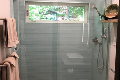 Mid-sized trendy 3/4 blue tile and glass tile beige floor bathroom photo in New York with dark wood cabinets, a wall-mount toilet, beige walls, a vessel sink and marble countertops