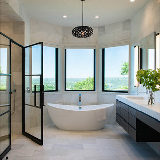 Esempio di una stanza da bagno padronale minimal con ante lisce, ante in legno bruno, vasca freestanding, lavabo integrato e porta doccia a battente