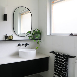 Design ideas for a large contemporary bathroom in Melbourne with flat-panel cabinets, black cabinets, white tile, white walls, a vessel sink, grey floor, white benchtops, an open shower, ceramic tile, pebble tile floors and engineered quartz benchtops.