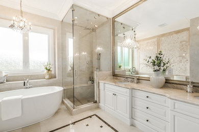 Large trendy master beige tile and mosaic tile marble floor and beige floor bathroom photo in Vancouver with raised-panel cabinets, white cabinets, beige walls, an undermount sink, marble countertops and a hinged shower door