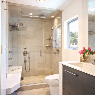 Bathroom - contemporary beige tile and limestone tile bathroom idea in Los Angeles with an undermount sink, flat-panel cabinets and dark wood cabinets