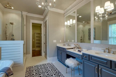 This is an example of a large traditional ensuite bathroom in DC Metro with raised-panel cabinets, blue cabinets, an alcove shower, beige tiles, beige walls, ceramic flooring, a submerged sink, marble worktops, beige floors and a hinged door.