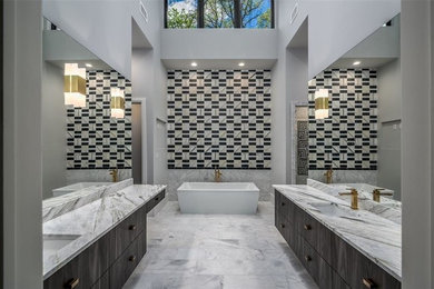 Exemple d'une très grande salle de bain principale tendance en bois foncé avec un placard à porte plane, une baignoire indépendante, un carrelage noir et blanc, du carrelage en marbre, un mur gris, un sol en marbre, un plan de toilette en marbre, un sol gris, un plan de toilette blanc et un lavabo encastré.