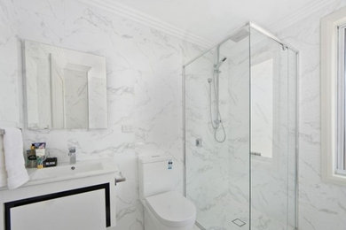 Réalisation d'une petite salle de bain minimaliste avec une douche d'angle, WC séparés, un carrelage blanc, du carrelage en marbre, un sol en marbre, un lavabo posé, un sol blanc et une cabine de douche à porte battante.