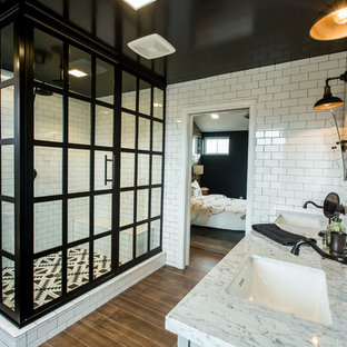 Modelo de cuarto de baño principal, industrial, con ducha esquinera, baldosas y/o azulejos blancas y negros, baldosas y/o azulejos de cemento, paredes blancas, suelo de madera en tonos medios y lavabo bajoencimera