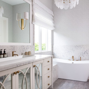 Exempel på ett modernt flerfärgad flerfärgat en-suite badrum, med möbel-liknande, beige skåp, ett fristående badkar, flerfärgad kakel, stenhäll och ett avlångt handfat