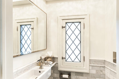 Imagen de cuarto de baño contemporáneo pequeño con lavabo suspendido, sanitario de pared, baldosas y/o azulejos grises, baldosas y/o azulejos de piedra y paredes blancas