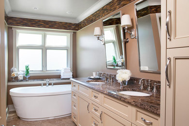 Inspiration för mellanstora moderna en-suite badrum, med luckor med infälld panel, beige skåp, ett fristående badkar, beige väggar, ett undermonterad handfat och granitbänkskiva