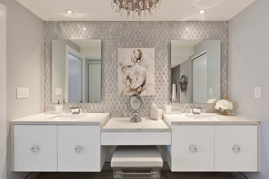 Diseño de cuarto de baño actual con armarios con paneles lisos, puertas de armario blancas, baldosas y/o azulejos blancos, paredes grises y lavabo bajoencimera
