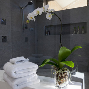 Mittelgroßes Modernes Badezimmer En Suite mit offenen Schränken, grauen Schränken, freistehender Badewanne, offener Dusche, grauen Fliesen, farbigen Fliesen, Spiegelfliesen, grauer Wandfarbe, Keramikboden, integriertem Waschbecken und Mineralwerkstoff-Waschtisch in Dallas