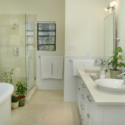 Inspiration for a mid-sized timeless master travertine tile, beige tile and white tile travertine floor freestanding bathtub remodel in Austin with shaker cabinets, white cabinets, a vessel sink, beige walls and marble countertops