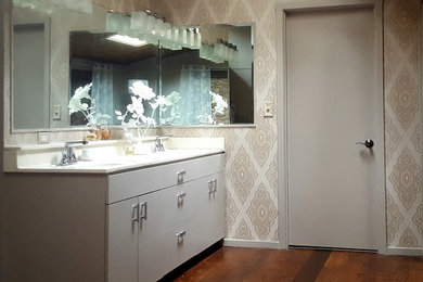 Ejemplo de cuarto de baño principal contemporáneo pequeño con armarios con paneles lisos, puertas de armario beige, paredes multicolor, suelo de madera oscura, lavabo integrado y encimera de acrílico