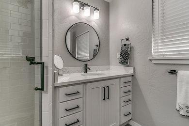 Example of a small trendy 3/4 white tile and subway tile alcove shower design in Oklahoma City with shaker cabinets, white cabinets, gray walls, an undermount sink, quartz countertops and a hinged shower door