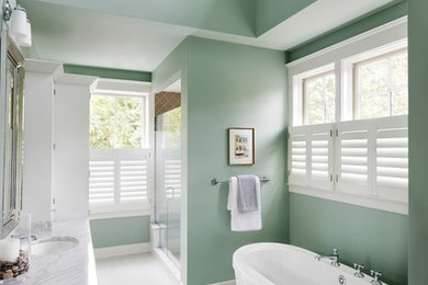 Example of a large trendy master ceramic tile and white floor bathroom design in Baltimore with green walls, a drop-in sink, marble countertops, a hinged shower door and gray countertops