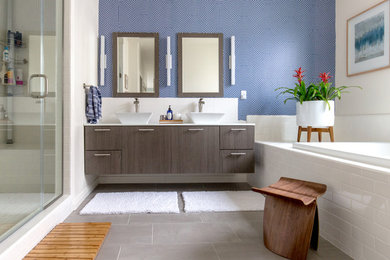 Diseño de cuarto de baño principal actual con armarios con paneles lisos, puertas de armario con efecto envejecido, baldosas y/o azulejos blancos, paredes azules y encimera de cuarzo compacto
