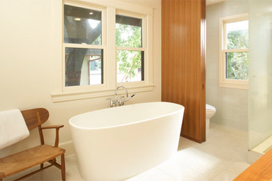 ミネアポリスにある広いコンテンポラリースタイルのおしゃれなマスターバスルーム (アンダーカウンター洗面器、フラットパネル扉のキャビネット、中間色木目調キャビネット、木製洗面台、置き型浴槽、アルコーブ型シャワー、一体型トイレ	、白いタイル、ガラスタイル、白い壁、テラゾーの床) の写真