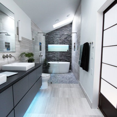 Example of a mid-sized trendy master gray tile and stone tile limestone floor bathroom design in Atlanta with flat-panel cabinets, gray cabinets and white walls