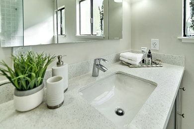 Example of a transitional master bathroom design in San Francisco with gray cabinets and quartz countertops