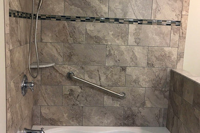 ニューヨークにあるお手頃価格の小さなコンテンポラリースタイルのおしゃれなマスターバスルーム (アルコーブ型浴槽、グレーのタイル、磁器タイル、ベージュの壁) の写真