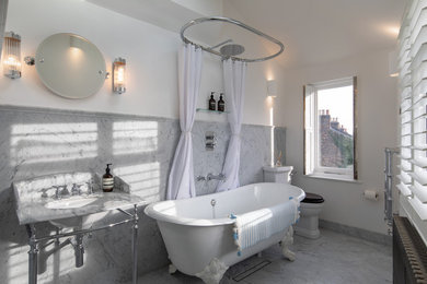 This is an example of a small victorian family bathroom in London with a claw-foot bath, a shower/bath combination, grey tiles, marble tiles, white walls, marble flooring and grey floors.