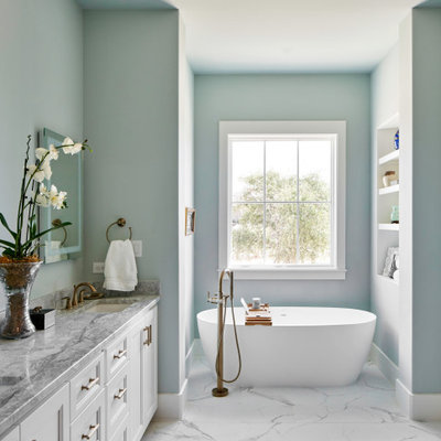 Freestanding bathtub - country white floor freestanding bathtub idea in Other with recessed-panel cabinets, white cabinets, blue walls, an undermount sink and gray countertops