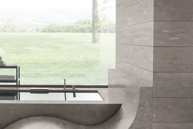 Réalisation d'une salle de bain avec un carrelage gris, un mur gris et un plan de toilette en surface solide.