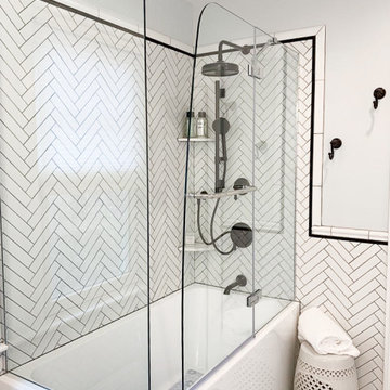 Corner Porcelain Tub with Herringbone Backsplash and Black Trim