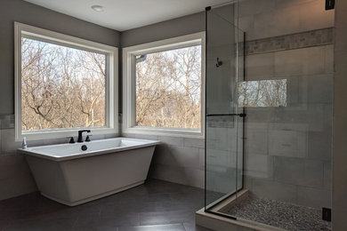 Imagen de cuarto de baño principal actual grande con bañera exenta, ducha esquinera y ducha con puerta con bisagras