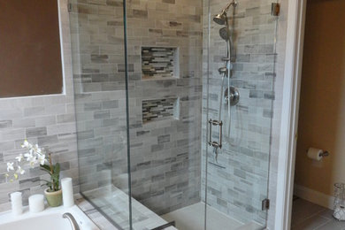 Modern bathroom in DC Metro with a corner shower, grey tiles and brown walls.