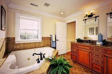 ワシントンD.C.にある高級な中くらいなコンテンポラリースタイルのおしゃれなマスターバスルーム (コンソール型シンク、レイズドパネル扉のキャビネット、中間色木目調キャビネット、御影石の洗面台、コーナー型浴槽、アルコーブ型シャワー、一体型トイレ	、マルチカラーのタイル、セラミックタイル、ベージュの壁、セラミックタイルの床) の写真