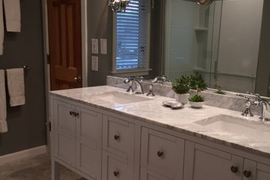 Imagen de cuarto de baño clásico de tamaño medio con puertas de armario blancas y encimera de mármol
