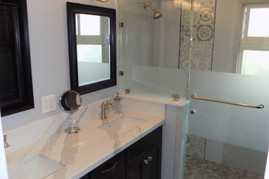 Shabby-Style Badezimmer mit Schrankfronten im Shaker-Stil, schwarzen Schränken, offener Dusche, Toilette mit Aufsatzspülkasten, grauen Fliesen, Porzellanfliesen, grauer Wandfarbe, Porzellan-Bodenfliesen, Unterbauwaschbecken, Quarzwerkstein-Waschtisch, grauem Boden und Falttür-Duschabtrennung in San Diego
