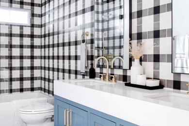 Small eclectic kids' black and white tile and cement tile cement tile floor and black floor bathroom photo in Orange County with shaker cabinets, blue cabinets, a one-piece toilet, white walls, an undermount sink, quartzite countertops, a hinged shower door and white countertops