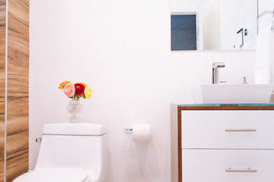 オレンジカウンティにある小さなコンテンポラリースタイルのおしゃれなバスルーム (浴槽なし) (家具調キャビネット、中間色木目調キャビネット、アルコーブ型浴槽、シャワー付き浴槽	、一体型トイレ	、白い壁、セラミックタイルの床、ベッセル式洗面器、ガラスの洗面台、白い床、引戸のシャワー) の写真