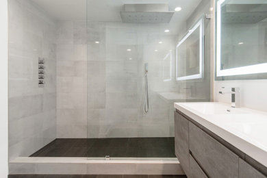 Mid-sized minimalist master porcelain tile and gray floor bathroom photo in Orange County with flat-panel cabinets, gray cabinets, gray walls, an integrated sink, quartz countertops and white countertops